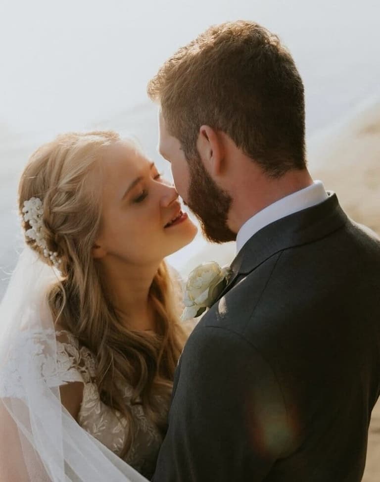 Bride with braided half-up hairstyle and floral pins by Blythe Beauty