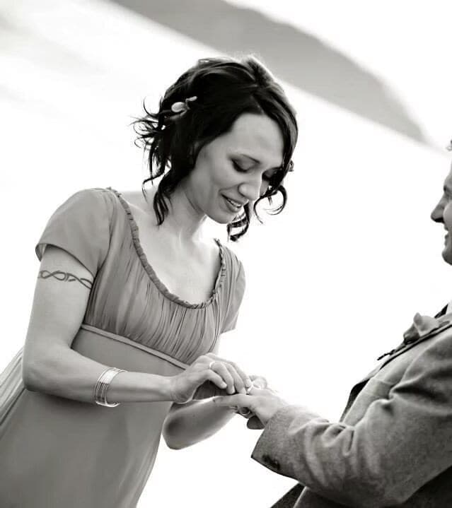 Bride with a soft pinned updo exchanging rings, in black and white