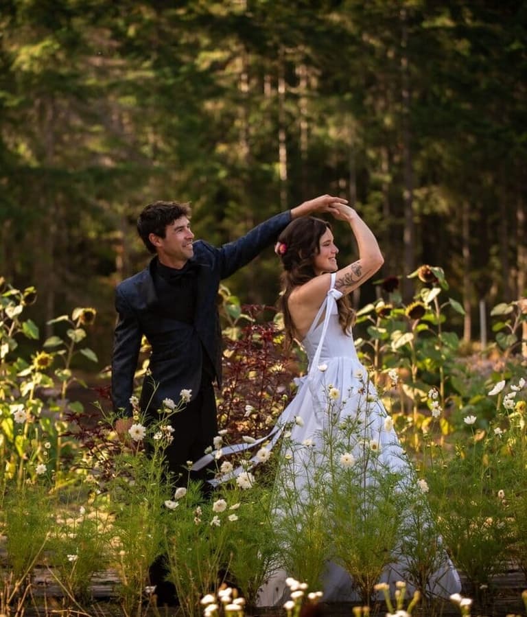 Groom twirling his bride among sunflowers at Flower Beds Farm