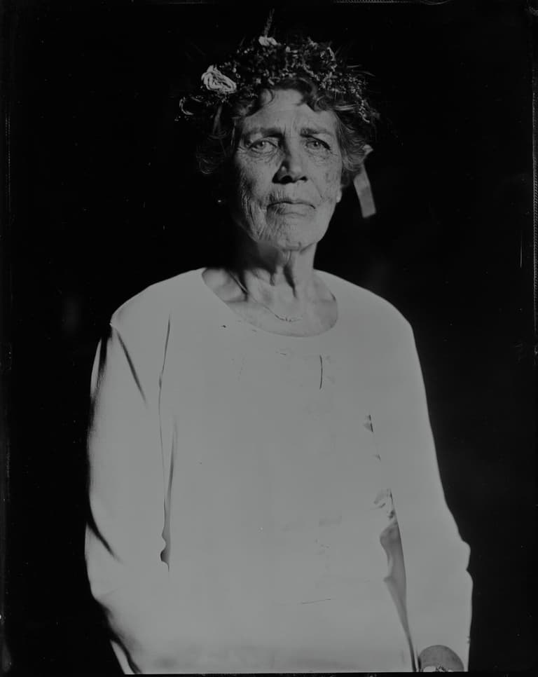 Elderly woman wearing a flower wreath, wet-plate portrait