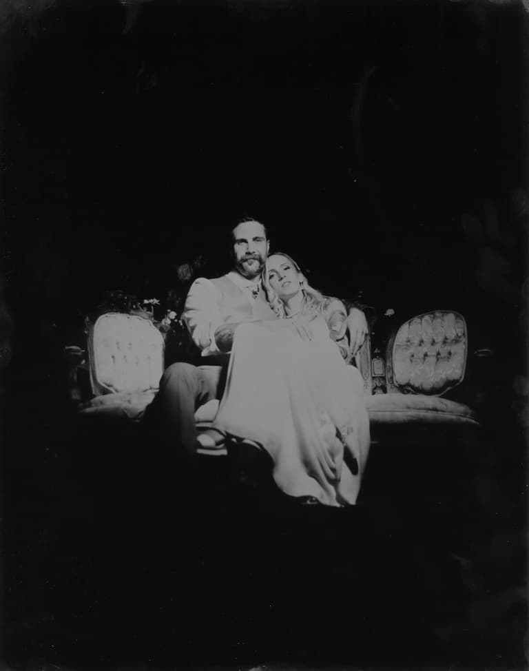 Moody tintype of a couple cuddled on an antique sofa