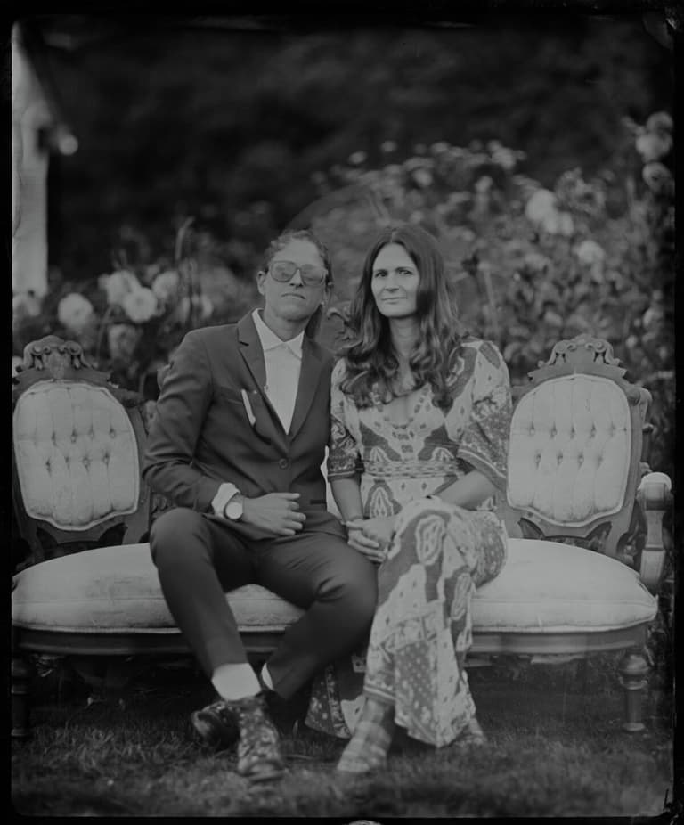 Tintype of a pair lounging on an antique loveseat among roses