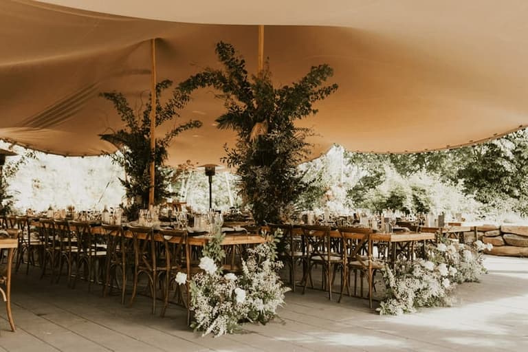 Sailcloth tent reception dressed in greenery at Bodega Ridge