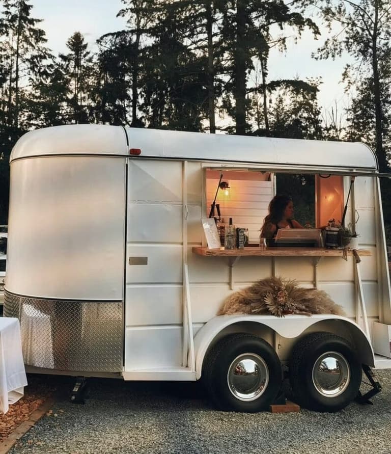 Vintage horse-trailer bar of West Coast Street Saloon at dusk