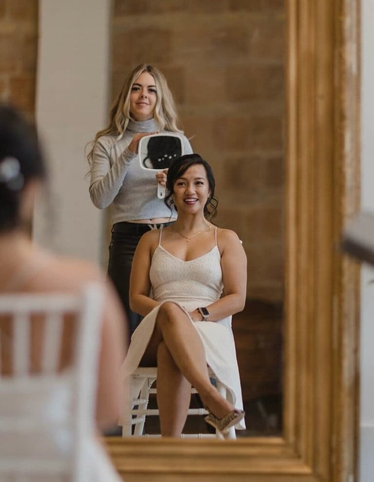 Hair by Bfriee stylist showing a bride her finished updo