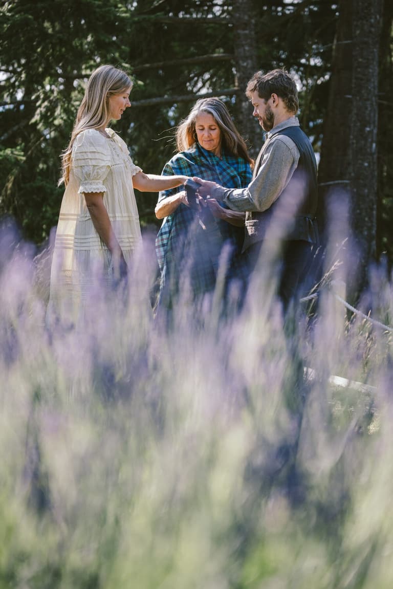 Officiant joining a couple's hands over the lavender field
