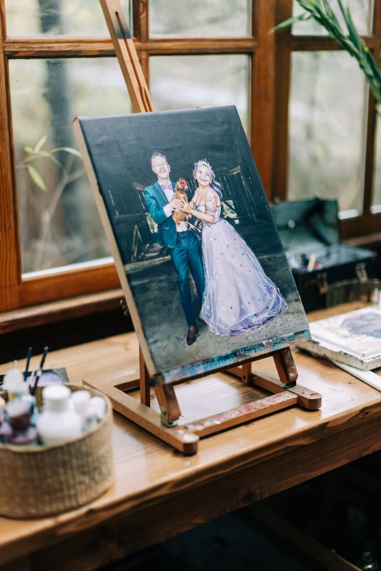 Finished live wedding painting of newlyweds and their dog on an easel