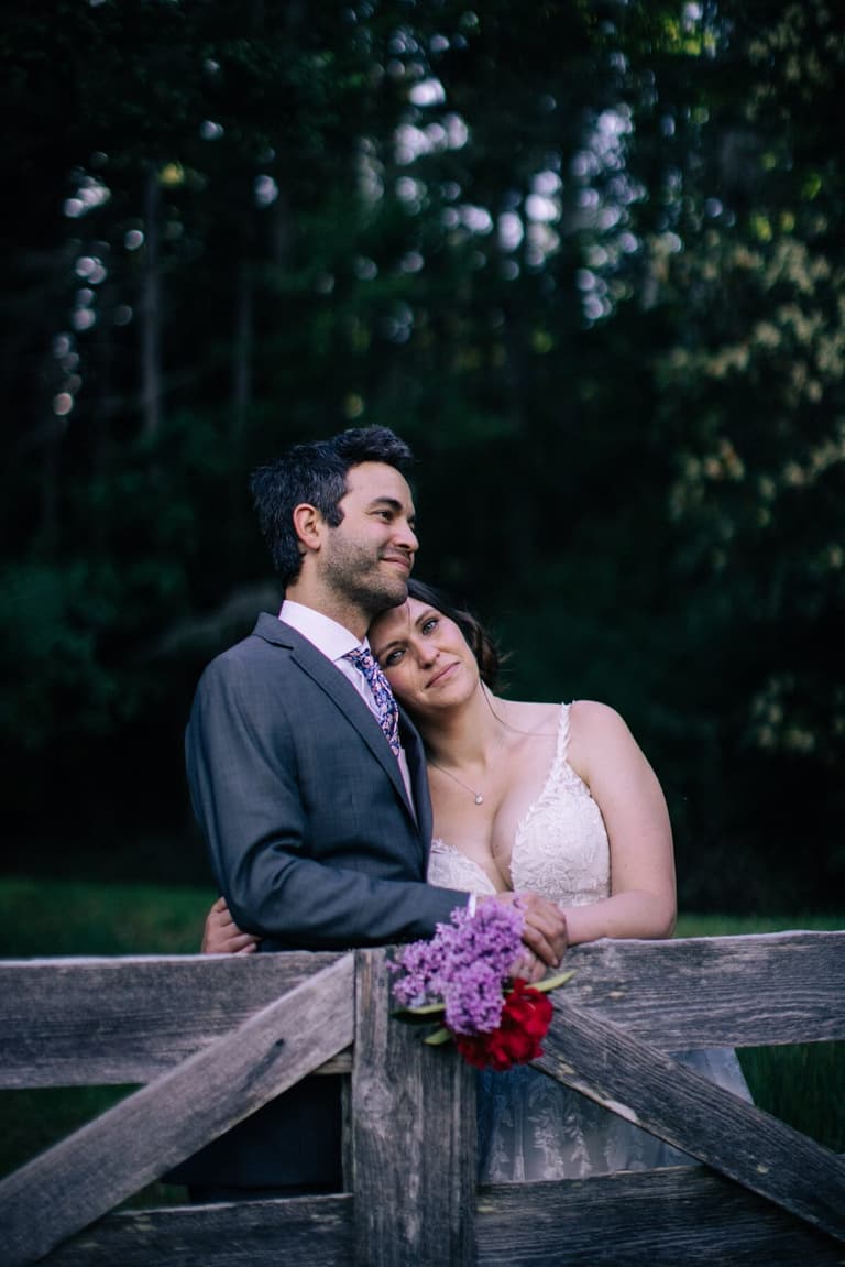 Bride resting her head on the groom's shoulder at the gate
