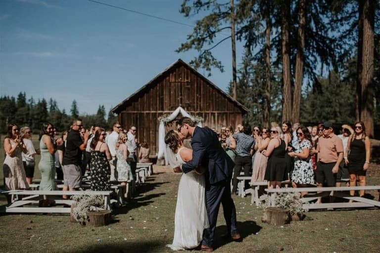Couple kissing mid-aisle at a Holly Hill Farm barn ceremony