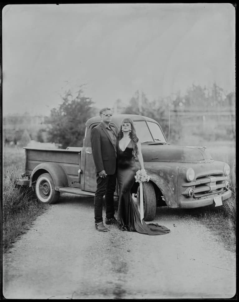Tintype couple posed beside a vintage pickup truck