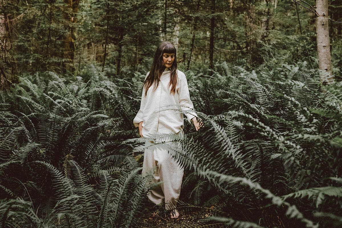 Stasia Garraway standing among waist-high sword ferns in the forest