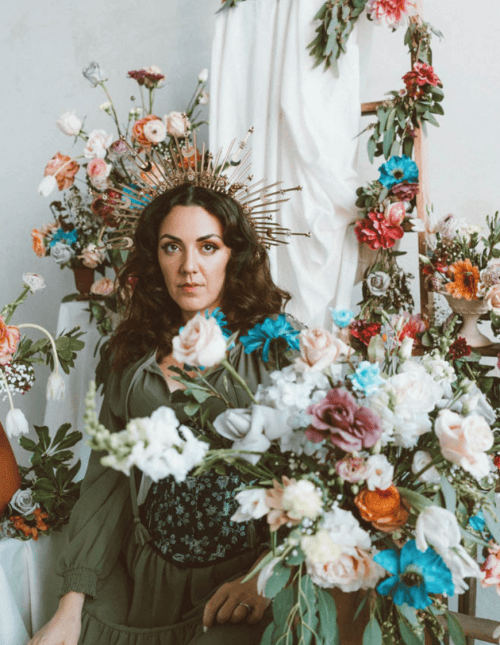 Florist in a gilded crown amid Evermore House floral installations