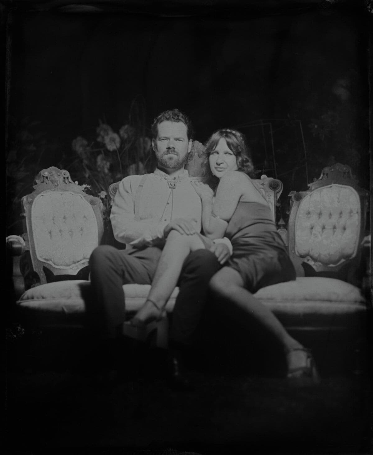 Tintype portrait of a couple entwined on an antique loveseat