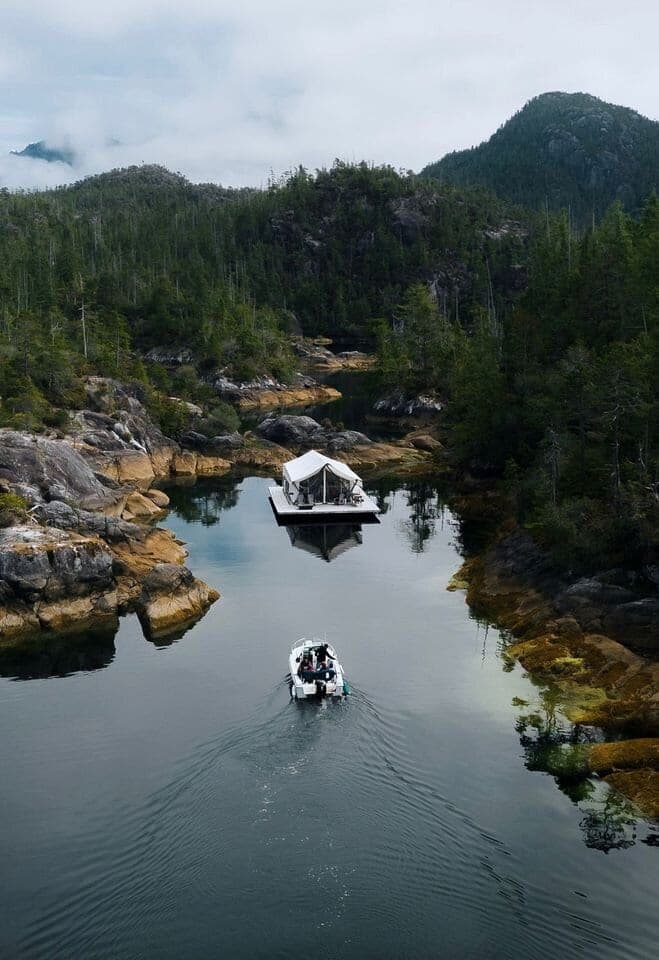 Boat approaching Lux.Remote's floating tent in a quiet inlet