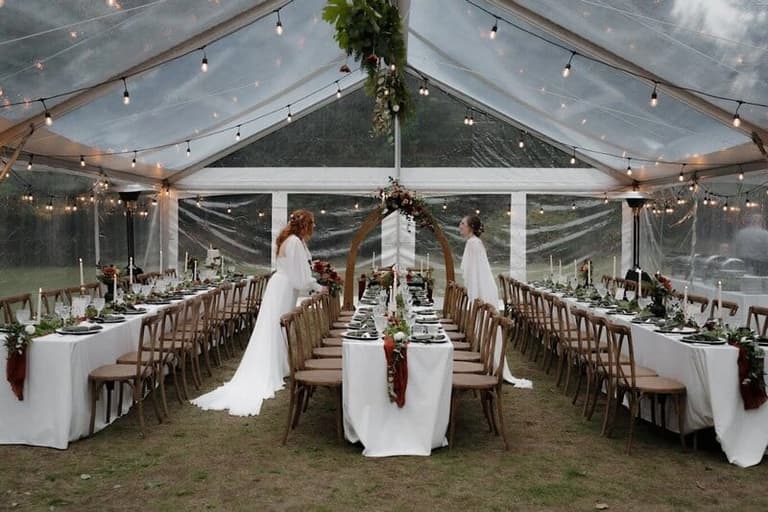 Clear-top tent reception furnished by Black & White Event Rentals