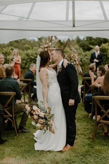 Newlyweds kissing beneath a tent at a Lavish Engagements celebration