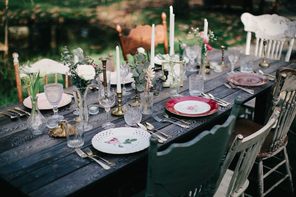Vintage tablescape with taper candles and mismatched chairs by Old New Borrowed Blue