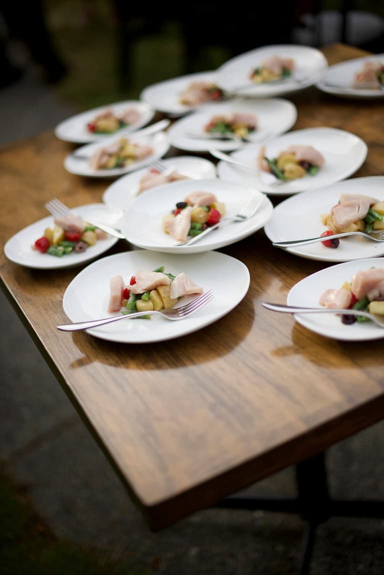 Plated appetizers arranged across a wooden harvest table