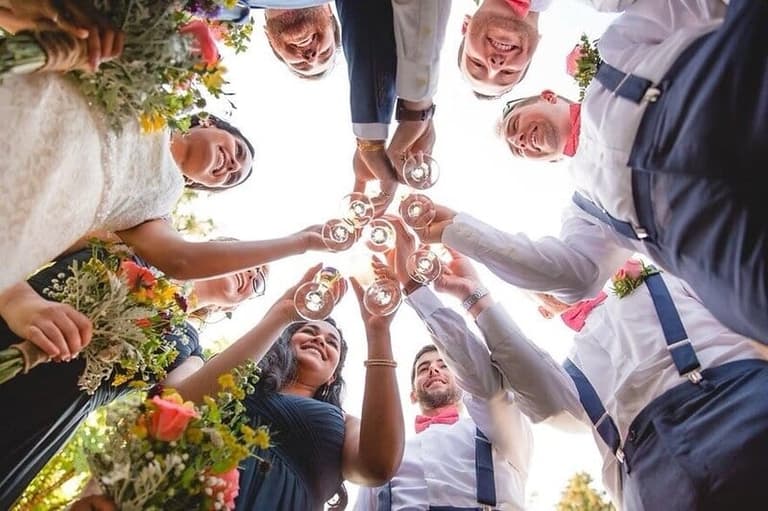 Wedding party toasting champagne in a circle seen from below