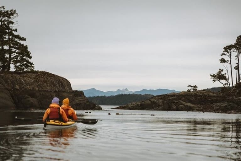Tandem kayakers exploring rocky islets with Kingfisher Wilderness Adventures
