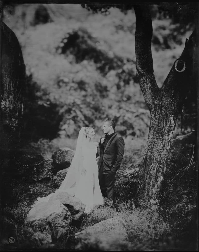 Wet-plate portrait of newlyweds standing among mossy rocks