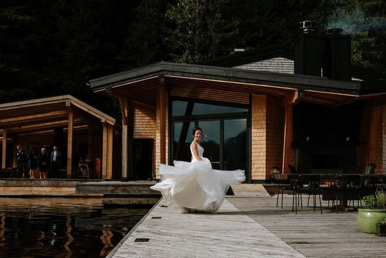 Bride twirling her gown on the boardwalk at Nimmo Bay Resort