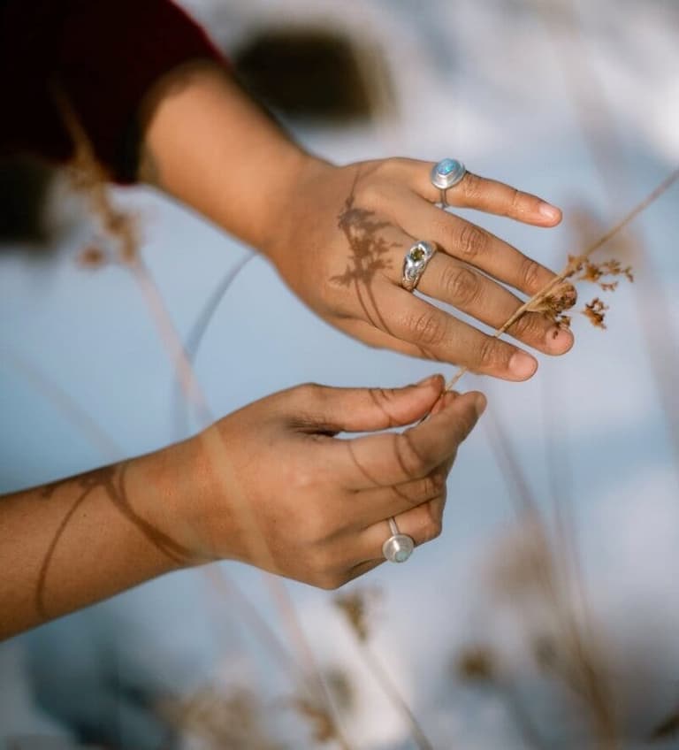 Silver gemstone rings from OPAL Jewellery Studio worn among dried grasses