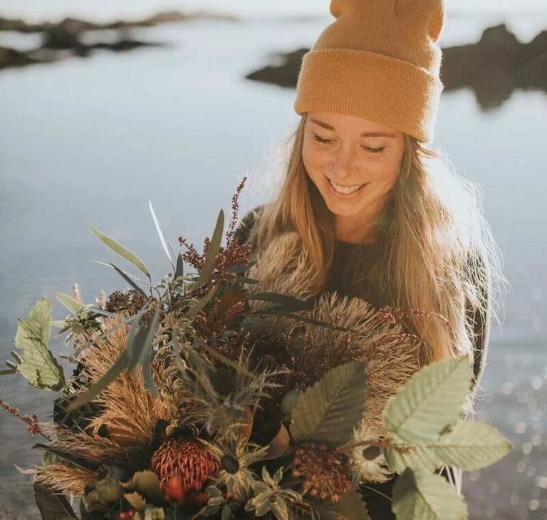 Florist standing at Oceanside with her Tofino wedding bouquet