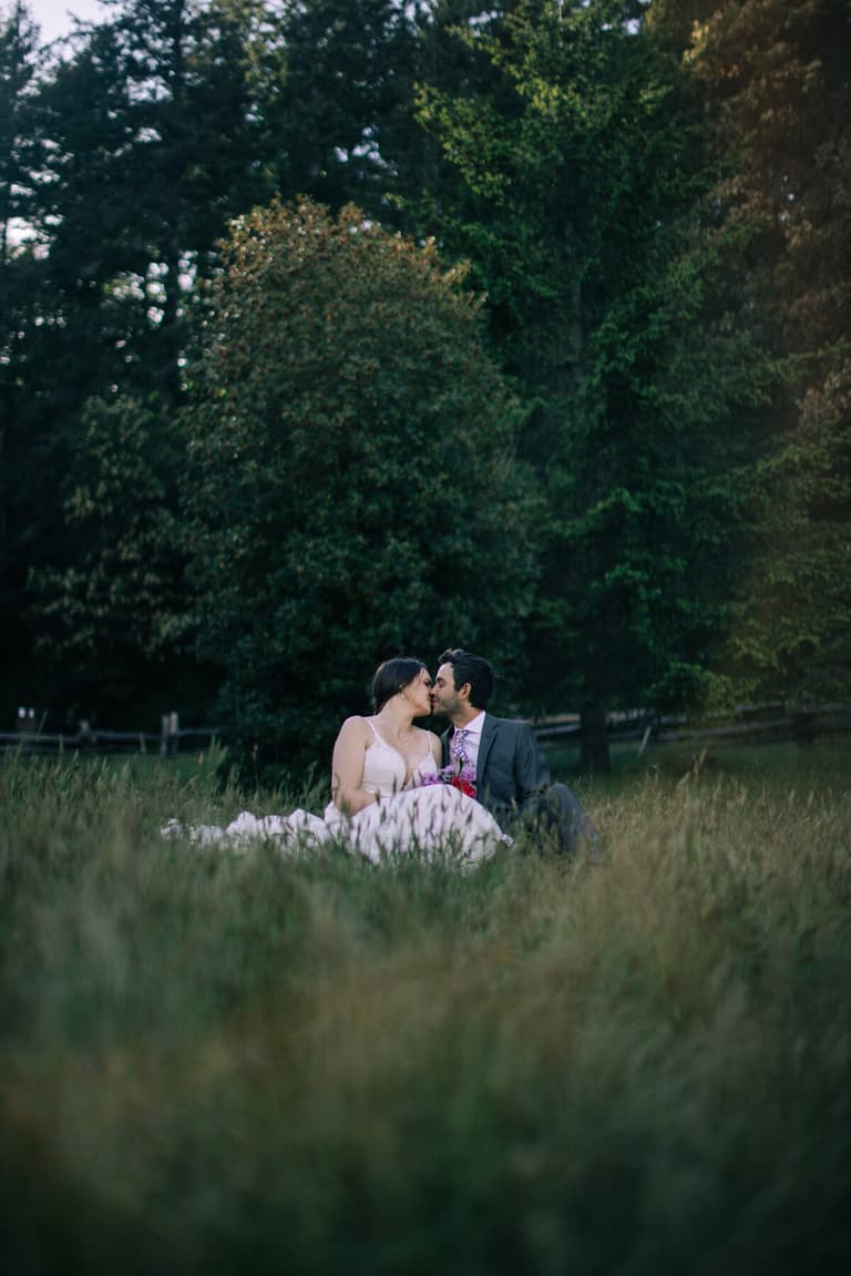 Bride and groom nose to nose in the tall grass