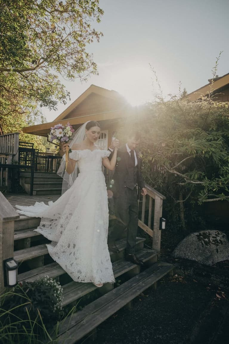 Newlyweds descending sunlit wooden steps at Galiano Inn and Spa