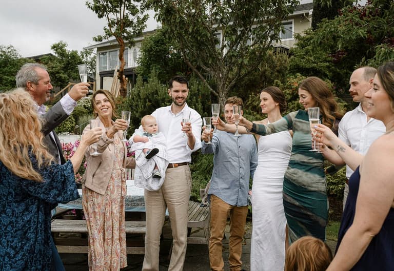 Guests raising champagne flutes for a garden wedding toast