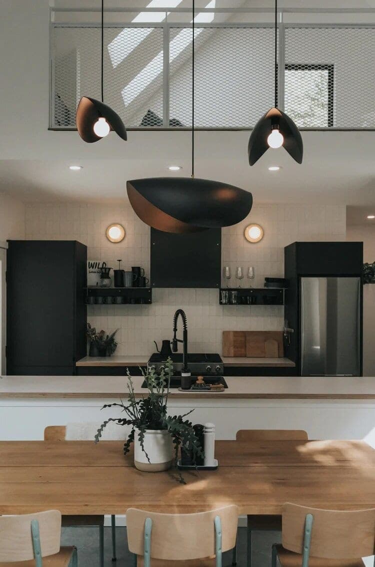 Modern cabin kitchen with black cabinetry and long wooden dining table