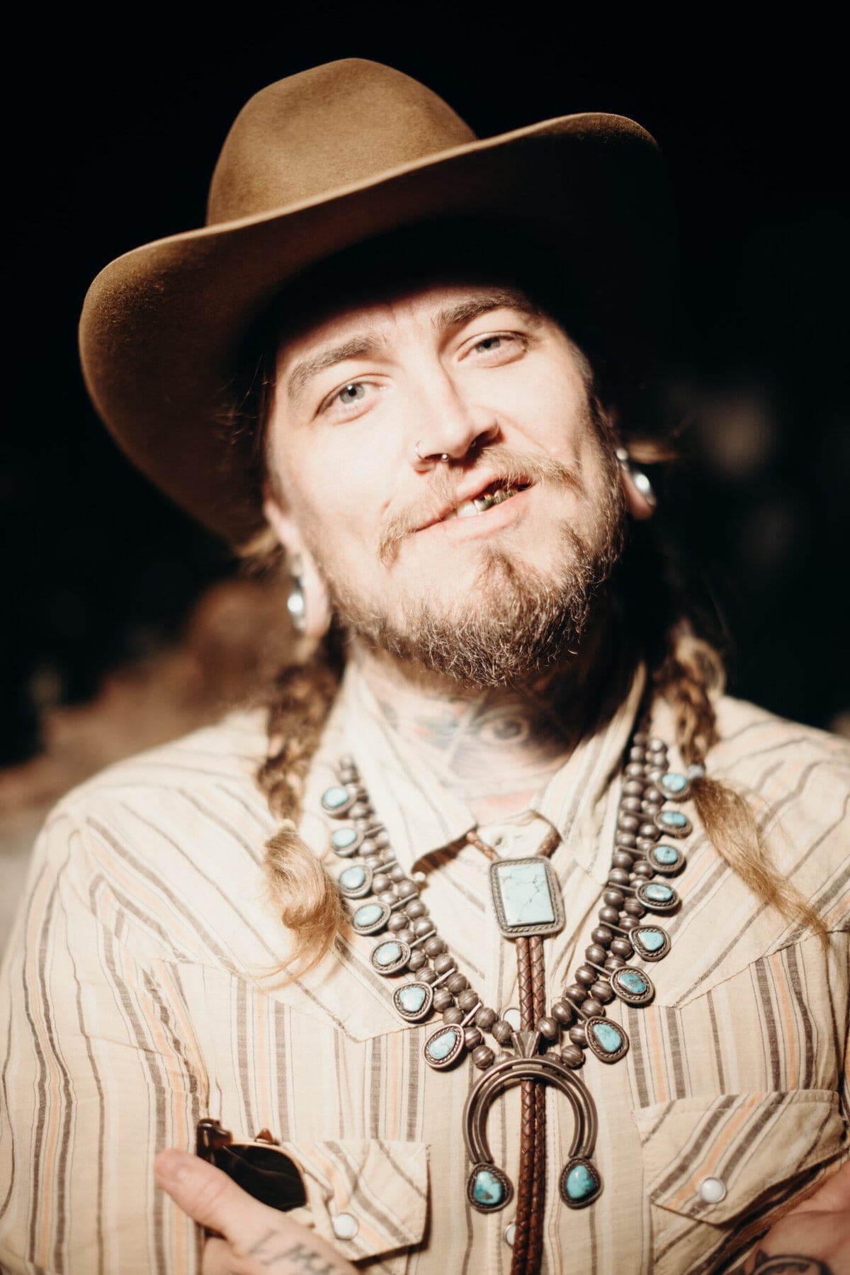 Grinning guest in cowboy hat and turquoise squash-blossom necklace