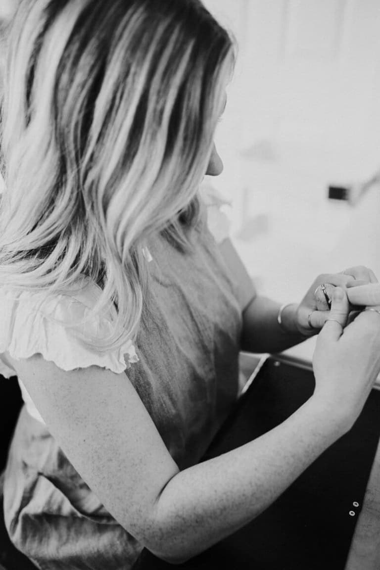 Emily Hartwell working a delicate jewelry piece by hand, black and white