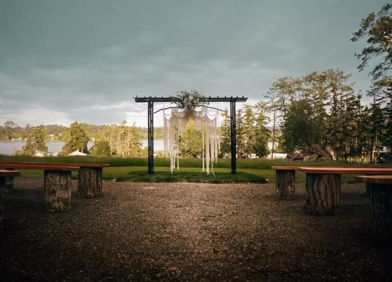 Macrame ceremony arbour and log benches at Brannen Lake Estates